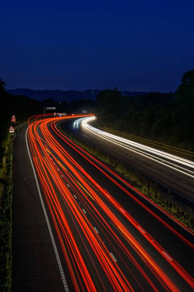 Traffic light trails of vehicles moving at speed along the M5 motorway in England UK.